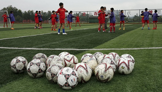 Students warm up before a training session at Evergrande soccer academy in Qingyuan, southern China